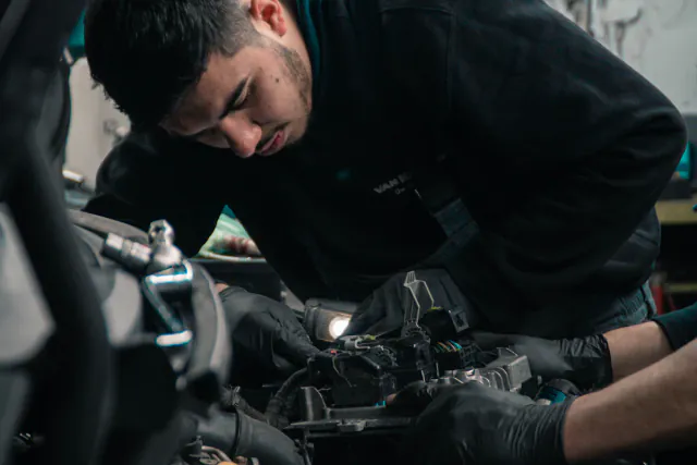 Mecánico revisando el motor de un coche en el taller